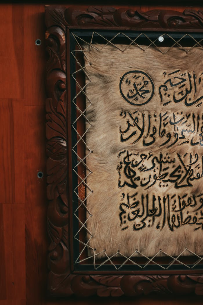 services-02 Close-up of traditional Arabic calligraphy framed in ornate wood, showcasing cultural art.
