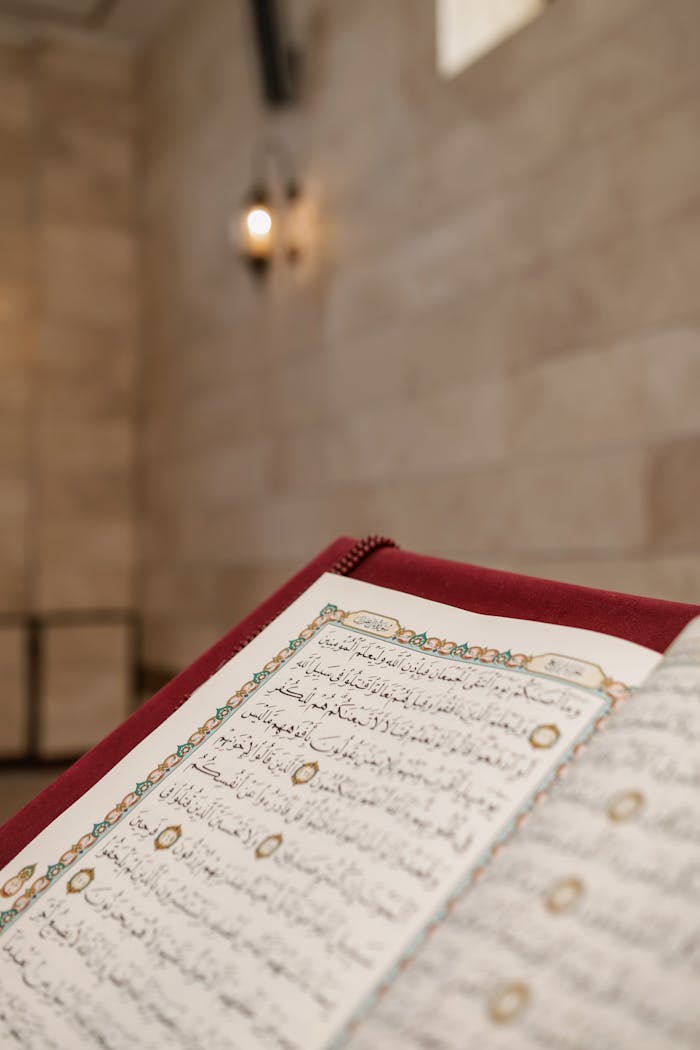 gallery-2 Close-up of an open Quran with intricate Arabic calligraphy in a mosque setting, highlighting Muslim culture.